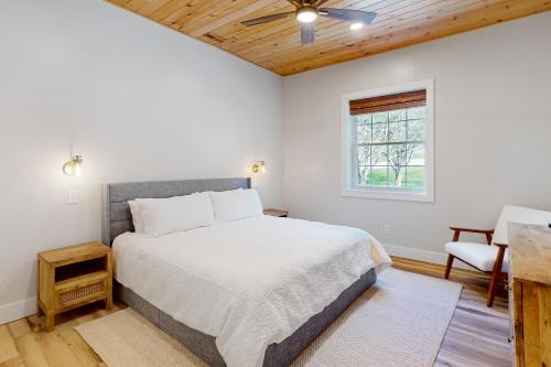 a bedroom with a large bed and a window at River Rock Cottage in Boone
