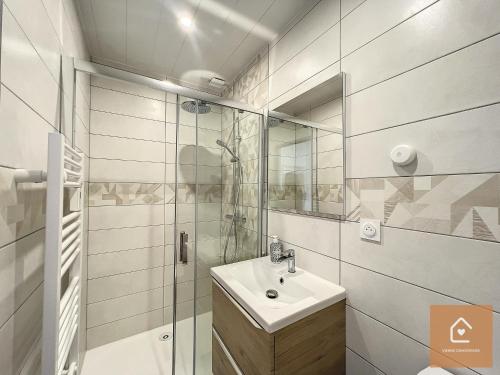 uma casa de banho branca com um lavatório e um chuveiro em Le blue Lagoon - 2 pers - Arrivée Autonome em Châtellerault