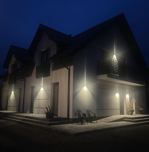 a house with lights on the side of it at night at Noclegi u Anny in Rzemień