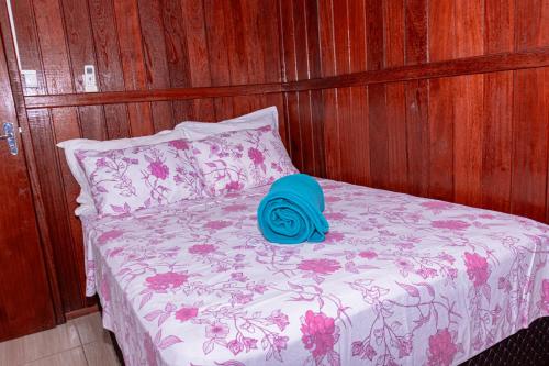 a bed with a blue hat on top of it at Casas do Seu Ari in Guarda do Embaú