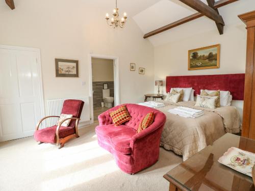 um quarto com uma cama, um sofá e uma cadeira em Sheep Pen Cottage em Durham