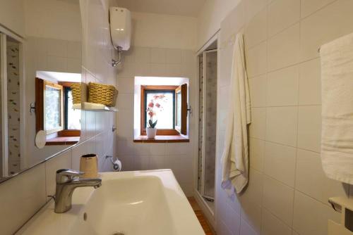 a white bathroom with a sink and a window at Agriturismo Casale le Crete in Acquapendente