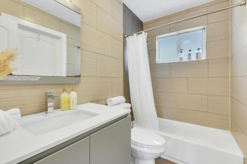 La salle de bains est pourvue d'un lavabo, de toilettes et d'un miroir. dans l'établissement Sunny Pompano Beach with pool access, à Pompano Beach