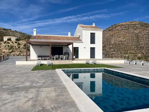 a villa with a swimming pool in front of a house at Vivienda en Granada, Cortijo Balcón Cotobro, Almuñécar, Casa con piscina y vistas increíbles in Granada
