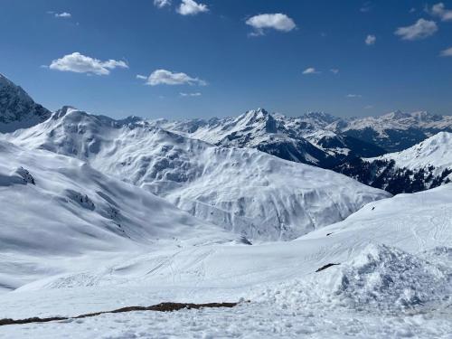 a snow covered mountain range with mountains in the background at Haus Maschol in Wald am Arlberg