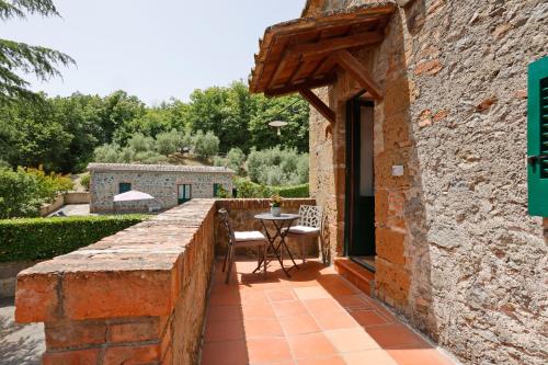 a stone wall with a table and chairs on a patio at Agriturismo Casale le Crete in Acquapendente