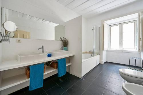 a white bathroom with two sinks and a toilet at Stunning Apartment near Chiado in Lisbon