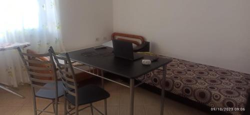 een bureau met een computer in een kamer bij Friends Hostel in Tirana