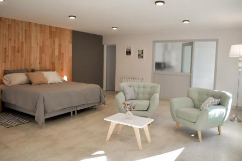 een slaapkamer met een bed en 2 stoelen en een tafel bij La Isabel in Esquel