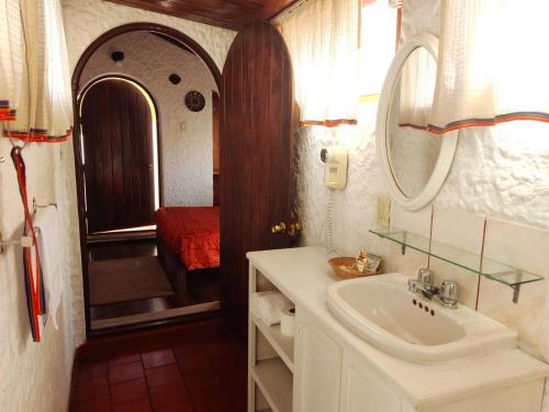 baño con lavabo, espejo y cama en Hotel La Casa de Tin tin, en Arequipa
