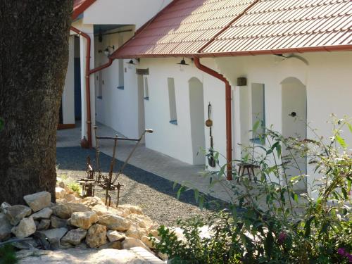 a row of white buildings with a tree and rocks at Penzión Záruby in Smolenice