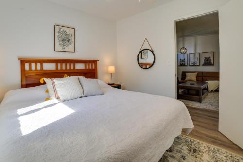 a bedroom with a large white bed and a living room at Higgins Lake Cottage with Private Fire Pit and Grill! in Roscommon