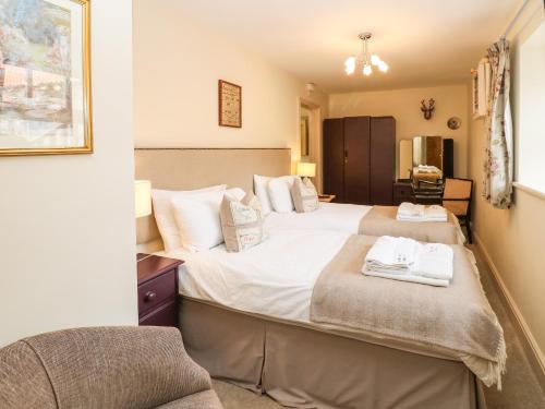 a bedroom with a large bed and a chair at Cross Cottage in Durham