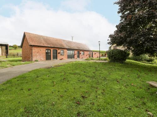a brick building with a grassy yard in front of it at The Pheasant One in Usk