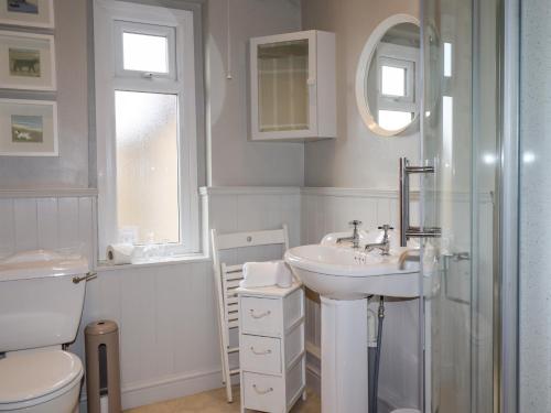 W łazience znajduje się umywalka, toaleta i prysznic. w obiekcie Fairhaven w mieście Alnmouth
