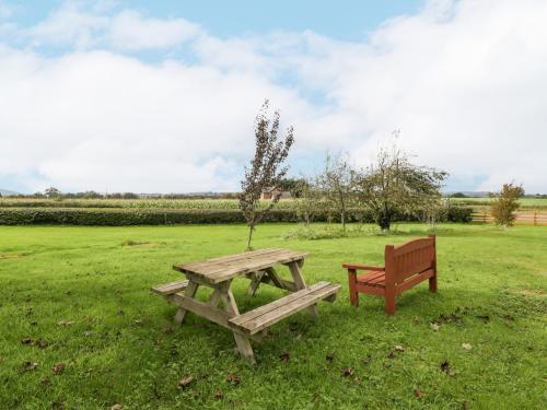 a picnic table and a bench in a field at The Pheasant One in Usk