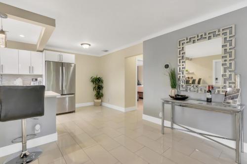 cocina y sala de estar con mesa y espejo en Pompano Jumbo - Sleeps 16 & priv pool, en Pompano Beach