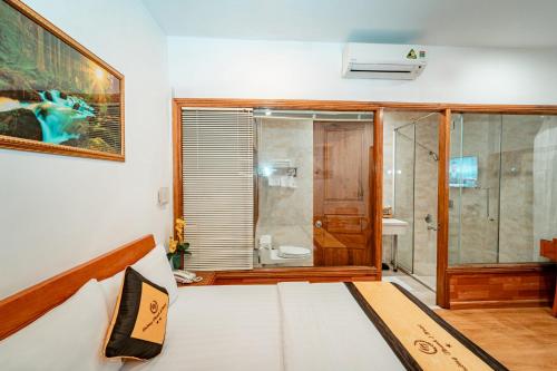 um quarto com uma cama e uma casa de banho com um chuveiro em Khách Sạn Cường Thanh 2 em Cidade de Ho Chi Minh
