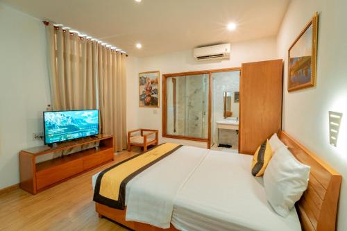 une chambre d'hôtel avec un lit et une télévision dans l'établissement Khách Sạn Cường Thanh 2, à Hô-Chi-Minh-Ville