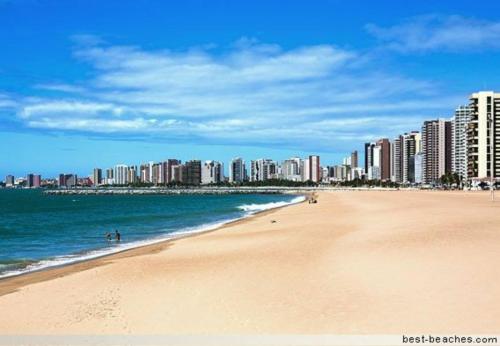 a beach with tall buildings and the ocean at POUSADA AREIA DA PRAIA in Fortaleza