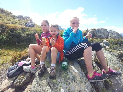 three girls sitting on a rock on a mountain at Apart Alpenpension Maderer in Gaschurn