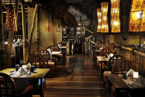 a restaurant with tables and chairs and chandeliers at Connaught Palace Hotel, Dubai in Dubai