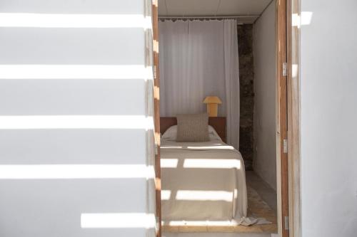 1 dormitorio con cama, ventana y espejo en Casa el Cantito en Las Aguas