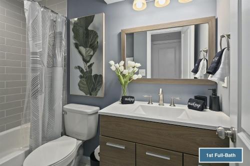 La salle de bains est pourvue d'un lavabo, de toilettes et d'un miroir. dans l'établissement Charming 3 bdr Thome, Suburban Nhbrhd, Near DC, à Sterling