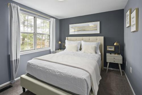 a bedroom with a large bed and a window at Charming 3 bdr Thome, Suburban Nhbrhd, Near DC in Sterling