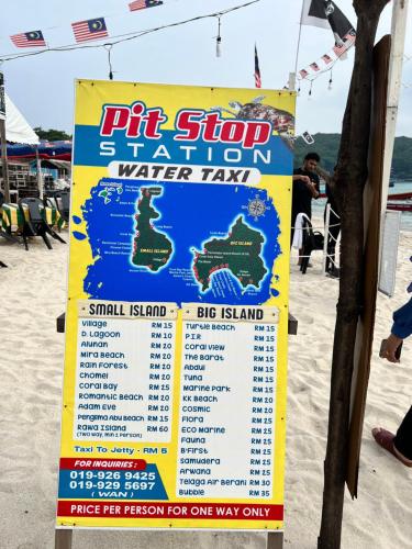 a sign for a water taxi on the beach at Perhentian Mama's in Perhentian Island
