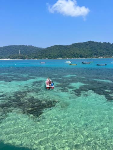 a group of people in a boat in the water at Perhentian Mama's in Perhentian Island