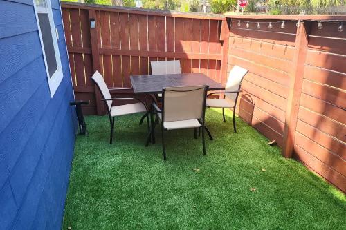 a patio with a table and chairs on the grass at The Gawdy Den with Fast WIFI 2 minutes from Downtown Houston! in Houston
