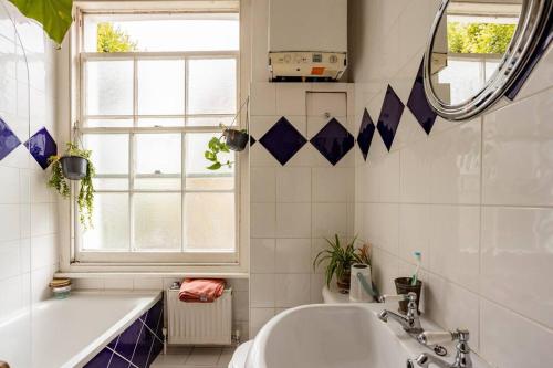 a bathroom with a tub and a sink and a mirror at ANGEL - Pleasant 1Bdr Apartment in London