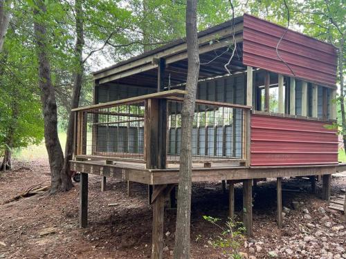 a tree house on a platform in the woods at The Happy Place In The Trees in Lake Murray Shores