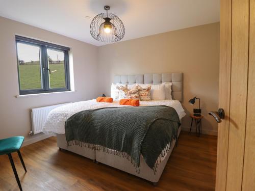 a bedroom with a bed with orange pillows on it at Mynydd Y Glyn Lodge in Llanfyllin