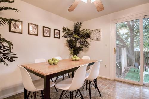 a dining room with a wooden table and white chairs at Spacious 3-story Townhome 40 Minutes from DC Pet-Friendly, Fast WiFi, Perfect in Sterling