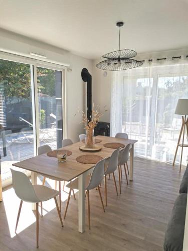 une table à manger et des chaises dans un salon dans l'établissement Les Cerisiers du Rouz, à Fouesnant