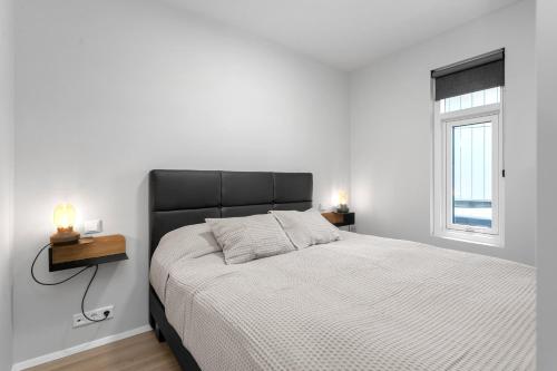 una camera bianca con un letto e una finestra di Grandinn Luxury apartment in Downtown Reykjavík a Reykjavik