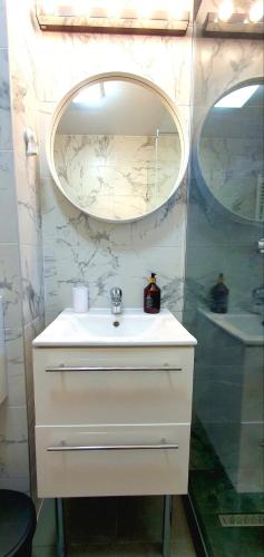 a bathroom with a white sink and a mirror at D&C Studio II/Self-Check-In in Bucharest