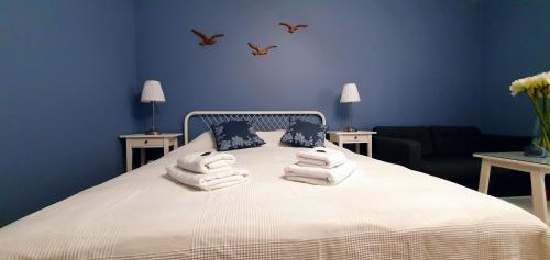 a blue bedroom with a bed with towels on it at D&C Studio II/Self-Check-In in Bucharest