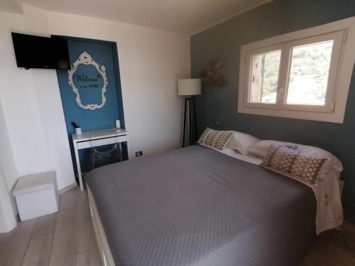 een slaapkamer met een groot bed en een raam bij La casa di Trilly in Sanremo