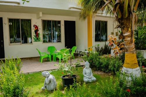 two statues sitting in the grass in front of a house at Caribbean Town Tolu in Tolú