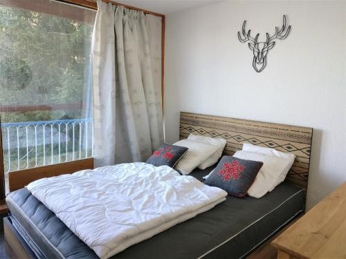 - un lit dans une chambre avec fenêtre dans l'établissement Appartement traversant · Ski aux pieds · Balcon · 4 pers - FR-1-346-461, à Arc 1800