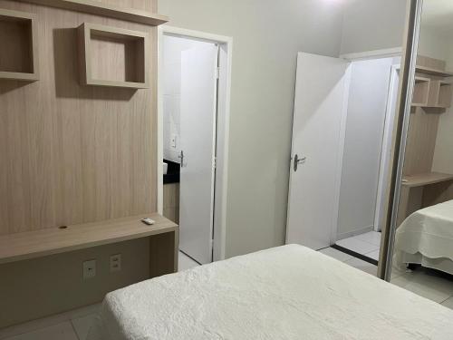 a room with two beds and a closet with a mirror at Férias na Bahia in Porto Seguro