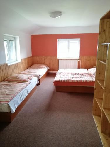 2 camas en una habitación con paredes y ventanas de color rojo en Bouda Svornost Pec pod Sněžkou, en Trutnov