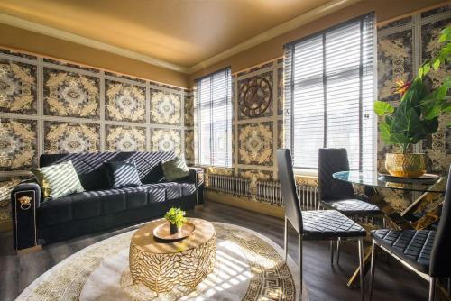 uma sala de estar com um sofá e uma mesa em Lux Versace Pad Sleeps 10 Hot Tub, Cinema & Games Room em Londres