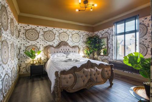 a bedroom with a large bed in a room with wallpaper at Lux Versace Pad Sleeps 10 Hot Tub, Cinema & Games Room in London