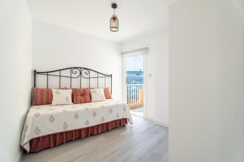 a white bedroom with a bed and a balcony at Susurros del Mar Sunset in Santa Cruz de Tenerife