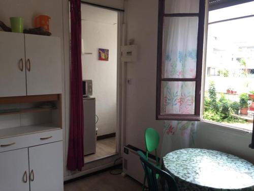 une salle à manger avec une table et une fenêtre dans l'établissement Cocon mignon A 2 pas de la plage, à La Ciotat