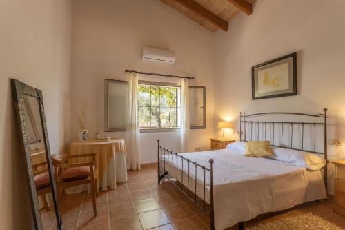 a bedroom with a bed and a table and a window at Villa La LLar Clara in Selva